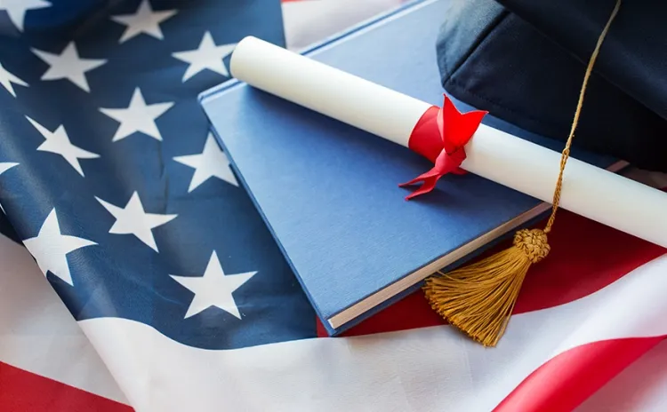 book with diploma certificat on top of the united states flag