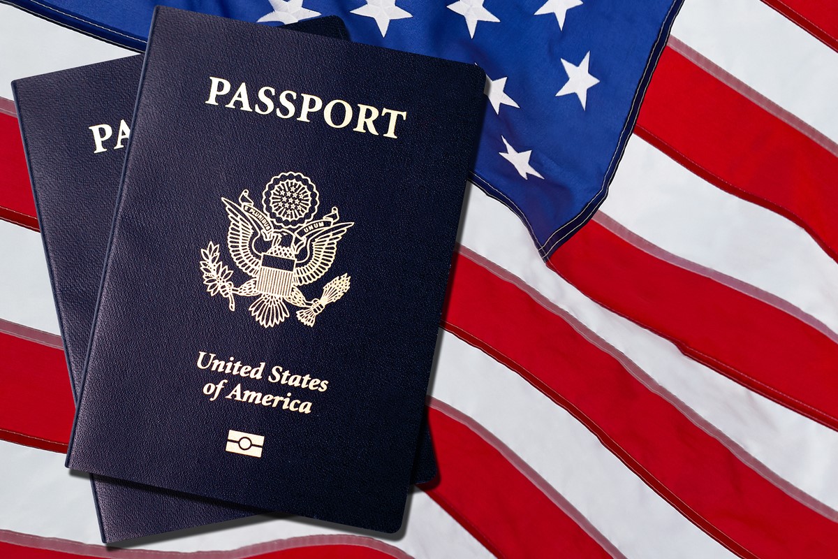 two united states passports with usa flag in the background